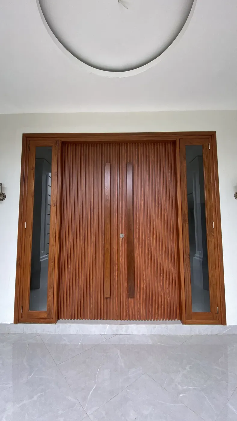 Pintu utama jati dua daun dengan panel kaca di kedua sisi
